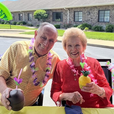 Two residents enjoying festive drinks at a celebration