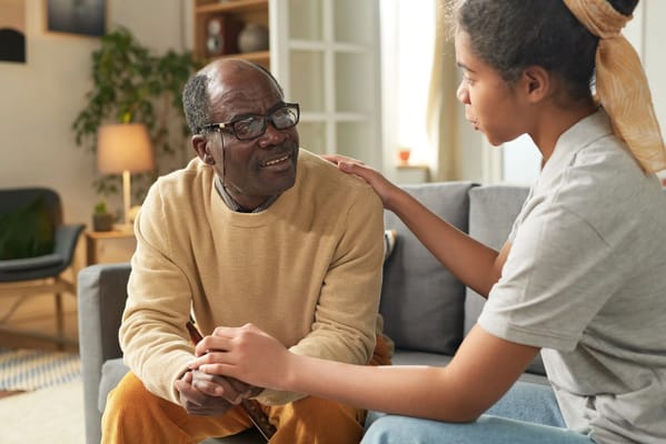 A resident and caregiver talking in a cozy living room
