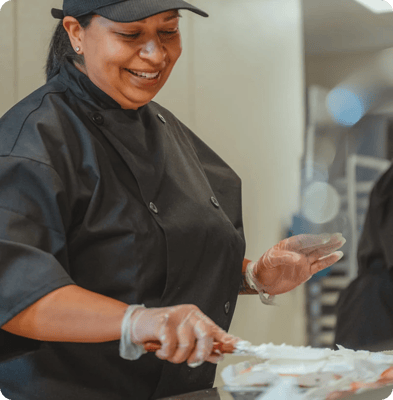 Staff member decorating a cake in the kitchen