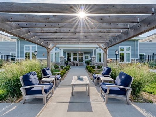 Outdoor seating area with shaded pergola and flowers