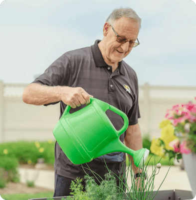 Resident gardening with a watering can in the outdoor space