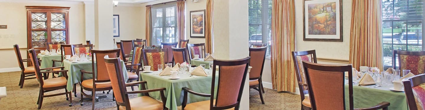 Dining room setup with tables and chairs ready for residents