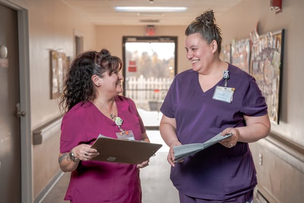 Two staff members conversing in a hallway