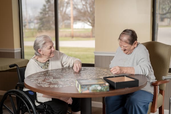 Two residents working on a puzzle together