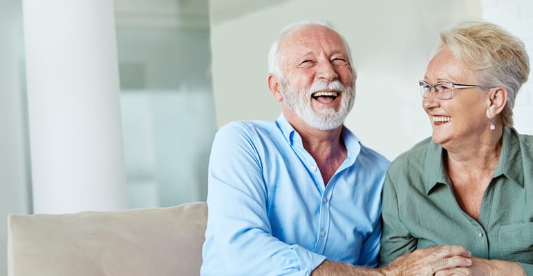 Couple laughing together in a warm interior setting