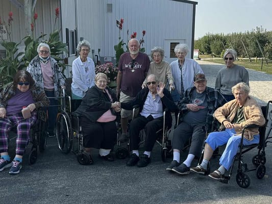 Group of residents posing outdoors at the facility