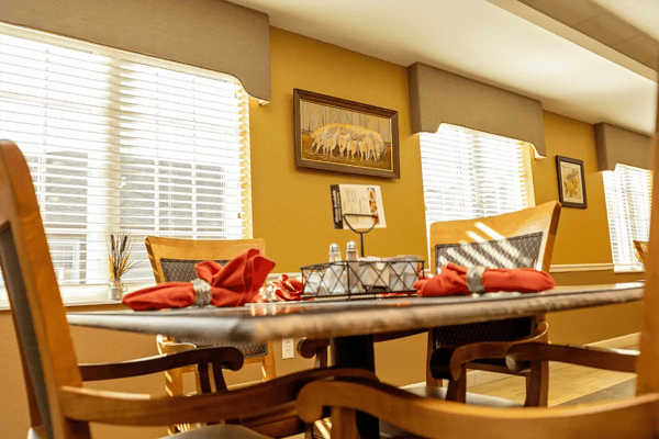Dining table set with red napkins in a bright dining room