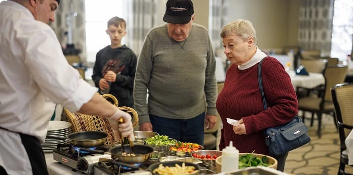 Residents enjoying a cooking demonstration in the dining area