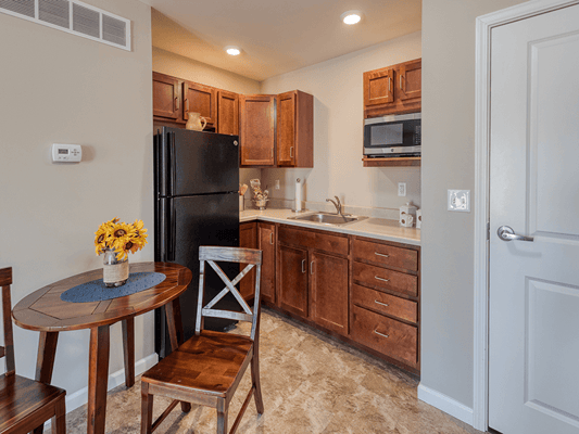 Bright kitchen area with wooden cabinets and table