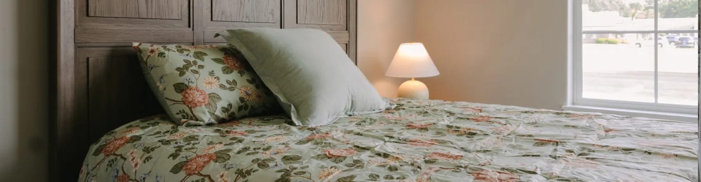 A cozy resident room with floral bedding and warm lighting
