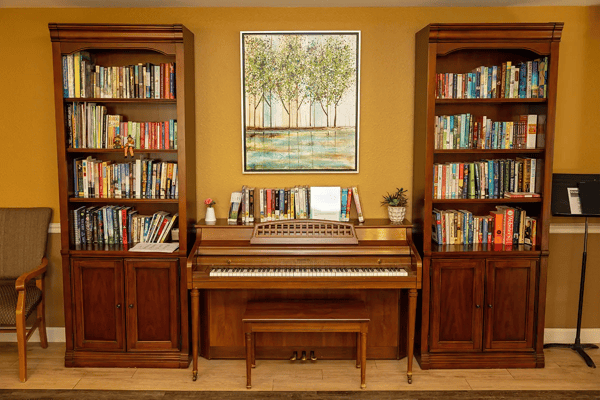 Interior view of a lobby with bookshelves and a piano