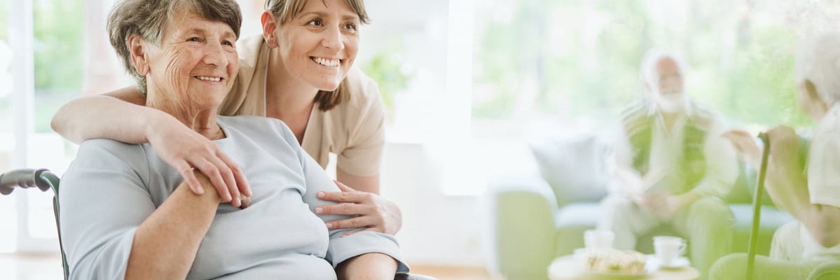 Resident and caregiver smiling in a common area