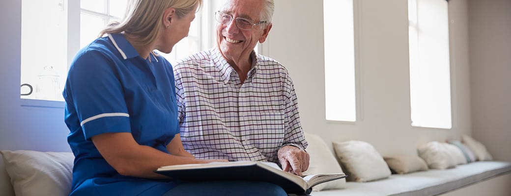 Staff member engaging with resident in a bright hallway