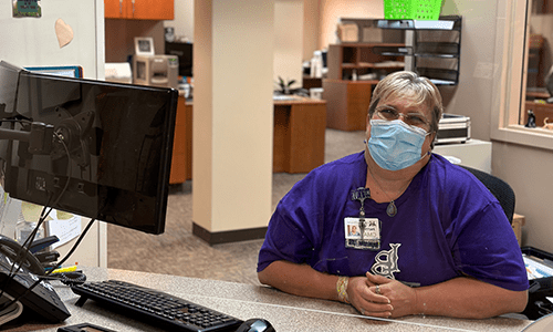 Staff member at reception wearing a mask
