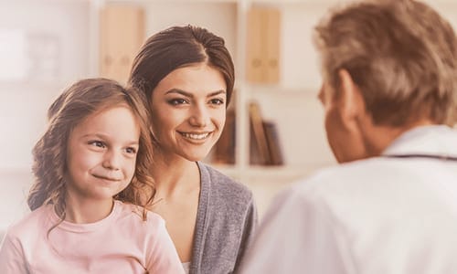 Smiling woman and child talking to a healthcare professional