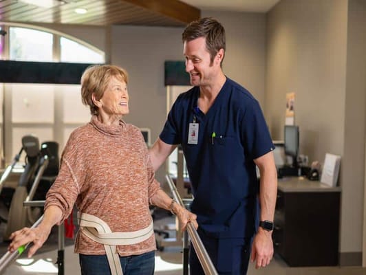 A caregiver assisting a resident with rehabilitation exercises