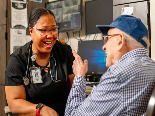 Staff member engaging with a resident in a lively conversation