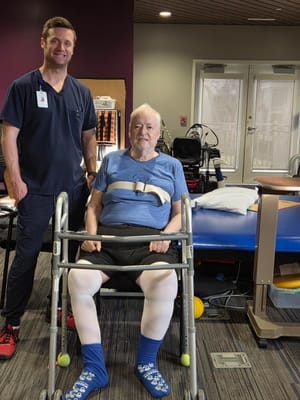 A healthcare professional assisting a resident in a therapy area