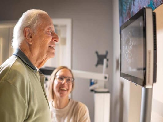Engaging interaction between a senior and staff member in an activity room