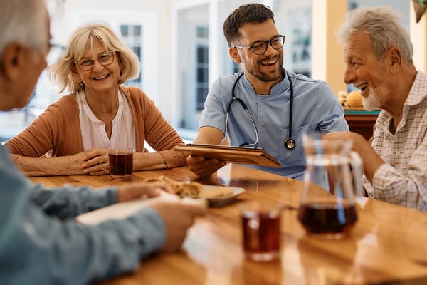 Residents enjoying time with a staff member over drinks
