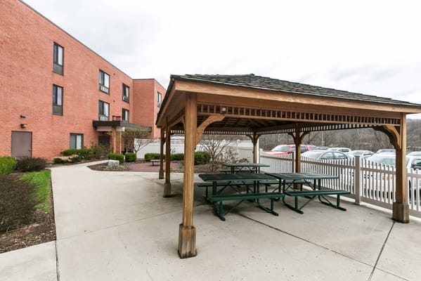 Outdoor gazebo with picnic tables near the facility