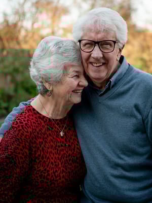Elderly couple smiling together in a natural setting