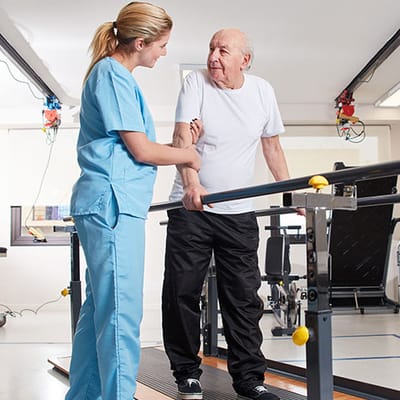Therapist assisting senior during rehabilitation