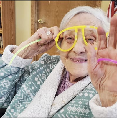 Resident playfully posing with oversized glasses