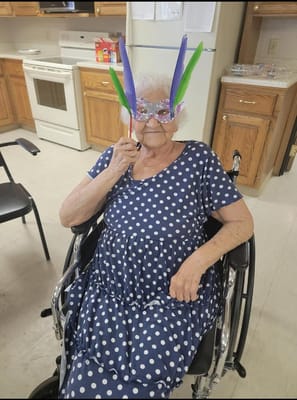 Resident in a polka dot dress wearing a festive mask
