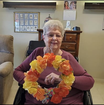 Resident holding a flower wreath in a cozy interior