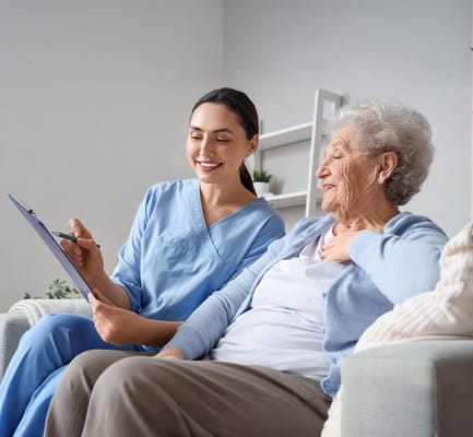 Caregiver engaging with a senior resident in a cozy living space