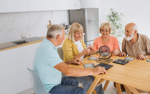 Residents playing bingo in a bright common area