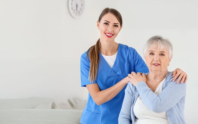 Nurse assisting an elderly woman in a bright interior