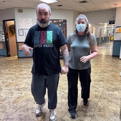 Two individuals walking in a facility hallway