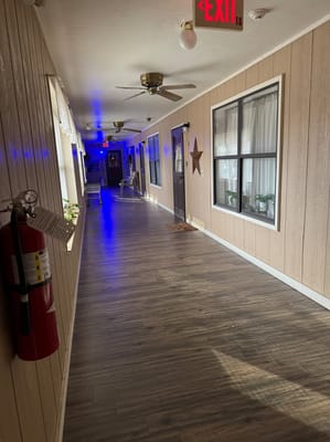 A well-lit interior hallway with wooden walls