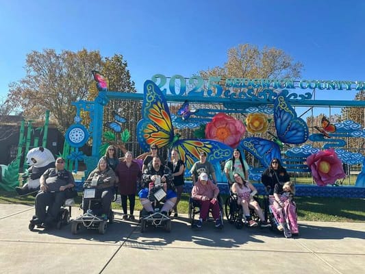 Residents and staff posing in front of colorful outdoor art