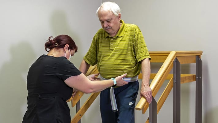 Staff assisting a resident with mobility support