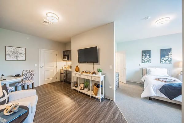 Interior view of a private resident room with a bed and kitchenette