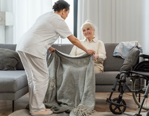 A caregiver assisting a senior resident with a blanket