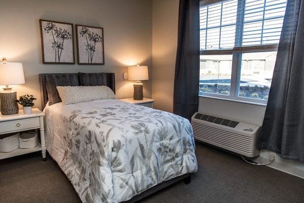 A cozy private room with a bed and natural light.