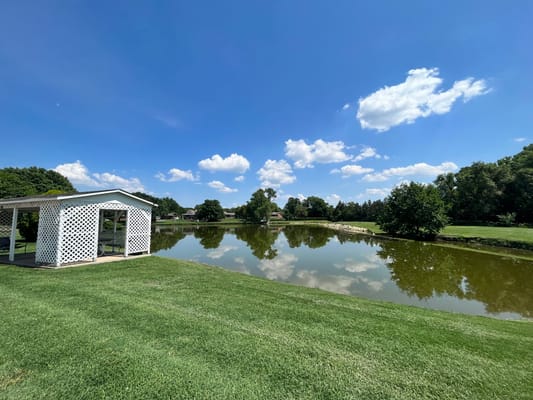 Scenic view of a pond with gazebo and grass