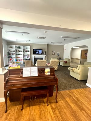 Interior view of a common area with a piano and seating
