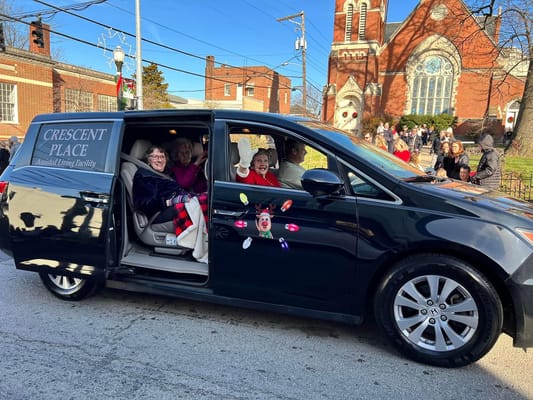 Residents enjoying a parade in a facility van