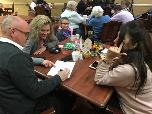 Residents and family interacting at a dining table