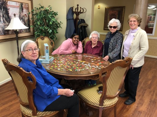Residents working on a puzzle in a common area