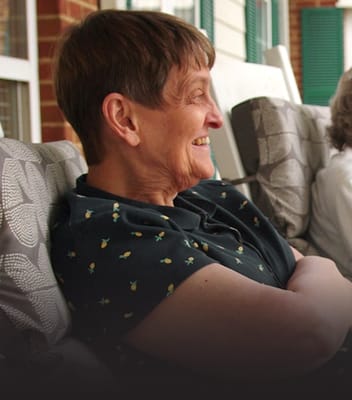 Smiling resident enjoying time outdoors on a porch