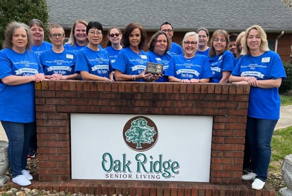 Staff members posing with an award outside the facility