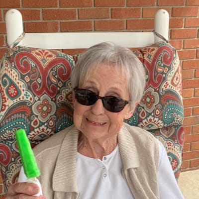 Resident enjoying a popsicle on a swing chair
