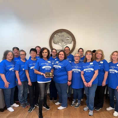 Staff members posing together with an award
