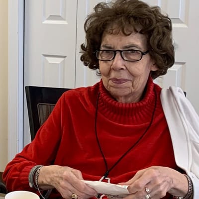 Resident smiling and holding a napkin in a cozy setting